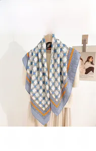 Detailed view of square silk scarf with chain print and herringbone pattern hanging