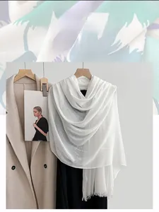 Detail of white linen scarf showing breathable fabric texture and fine fringe edge
