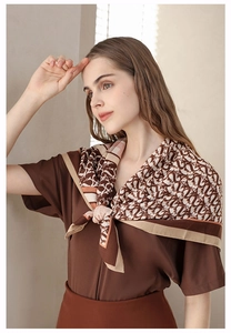 Elegant silk scarf with vintage letter print styled around the neck on a fashion model