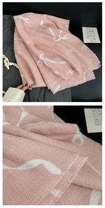 Detail eines rosa Kaschmir-ähnlichen Schals mit Schleifenmustern, Sternen und Fransenrand