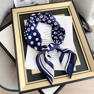 Dettaglio ravvicinato della sciarpa di seta blu navy con pois e strisce su fondo moda
