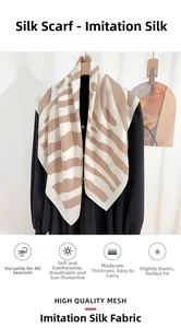 Détail d'un foulard en satin rayé élégant sur un haut noir montrant la texture du mesh