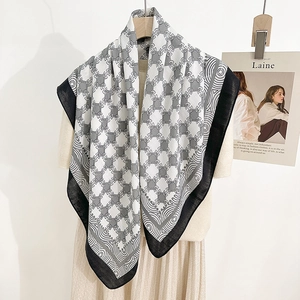 Elegant black and white square silk scarf with vintage geometric chain patterns on a hanger