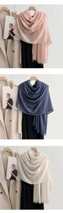 Detailed texture of linen scarves in pink, navy, and beige with soft fringe edges