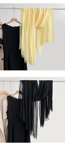 Detail of crinkled linen cotton scarf with frayed edges in light yellow and black