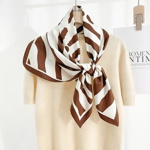 Élégant foulard en soie à rayures zébrées marron et blanc sur un haut en maille beige