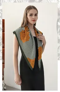 Detail of herringbone square scarf with orange floral prints and dark green hem