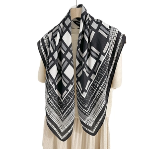 Elegant geometric print silk scarf with houndstooth pattern and linear border on dress