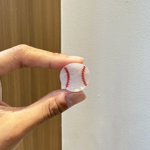 Vista dettagliata della piccola molletta per capelli da baseball con cuciture rosse in resina