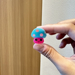 Nahaufnahme einer mini blauen Pilz-Haarklammer mit rosa Punkten und Smiley-Gesicht