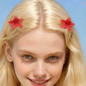 Cute red starfish hair clip with smiley face on blonde model against blue background
