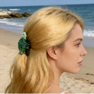 Dettaglio di un fermaglio per capelli a tartaruga verde su lunghi capelli biondi