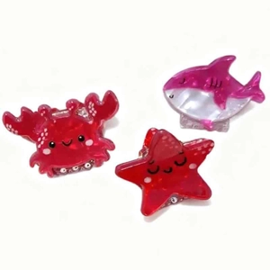Detail of glitter ocean animal hair clips featuring crab, shark and starfish designs