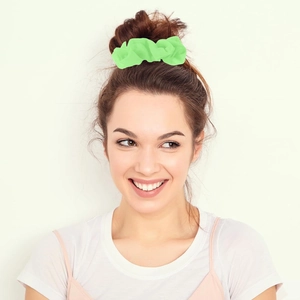 Neon green chiffon scrunchie with soft pleated texture on a woman's hair bun
