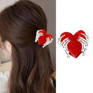 Dettaglio della pinza per capelli a cuore glitter rosa con mani di scheletro bianco
