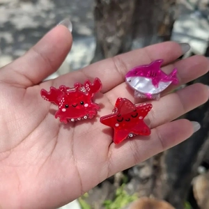 Cute ocean animal hair clips featuring a red crab, starfish, and pink shark with glitter