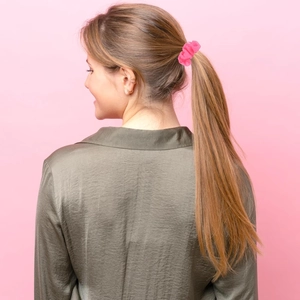 Pink chiffon scrunchie shown on a ponytail with a minimalist monochrome background