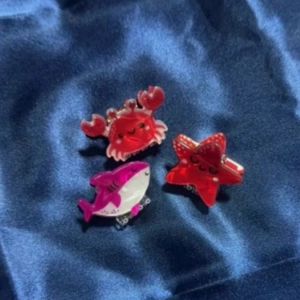 Set of cute acrylic ocean animal hair clips featuring a crab starfish and shark on blue silk