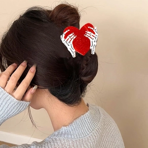 Pinza per capelli cuore di paillettes rosse con mani di scheletro su capelli raccolti