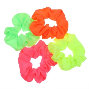 Close-up of four neon chiffon scrunchies in vibrant green orange pink and yellow colors