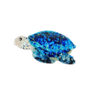 Dettaglio della molletta per capelli a tartaruga in acetato blu con motivi dorati
