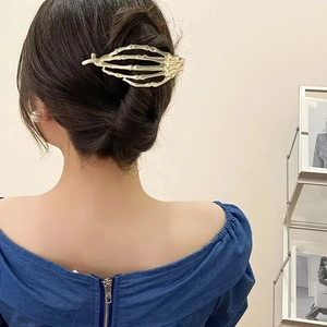Vue détaillée de la pince à cheveux main de squelette punk tenant un chignon chic