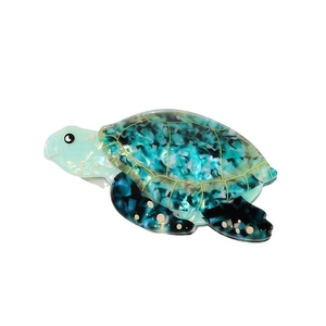 Dettaglio del fermaglio per capelli tartaruga marina in acetato marmorizzato blu e oro