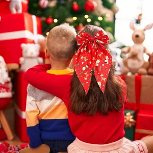 Festive red Christmas bow hair clip with reindeer and snowflake prints for girls