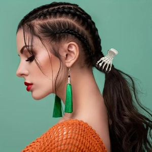 Gothic silver skeleton hand hair claw clip and emerald green silk tassel earrings on a model