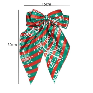 Christmas bow hair clip with red and green diagonal stripes and white snowflake patterns