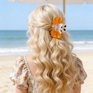 Cute goldfish hair claw clip accessory for beach styling on blonde wavy hair