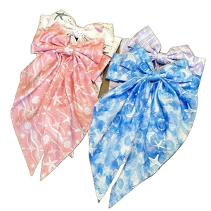 Three long-tail bow hair clips with starfish and seashell prints in assorted colors
