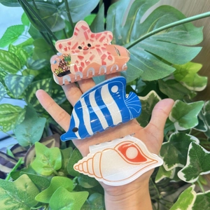 Ocean themed acrylic hair clips featuring starfish, tropical fish, and seashell designs