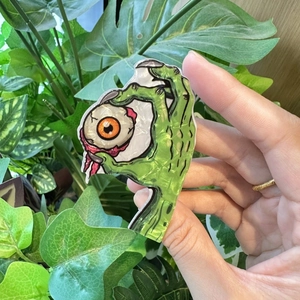 Green skeleton hand hair claw with eyeball detail in glossy pearlescent acrylic