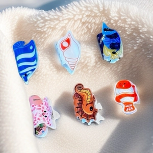 Macro shot of colorful ocean-themed hair claws featuring starfish and fish shapes