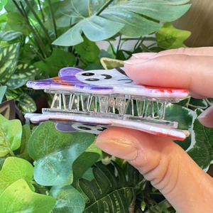 Playful witch claw clip featuring a cartoon face design with a purple hat for Halloween