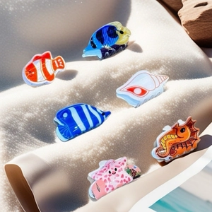 Collection of colorful ocean themed hair claws like starfish and seahorse on sandy beach