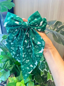 Détail d'un nœud papillon de Noël vert avec motifs de rennes blancs et de flocons