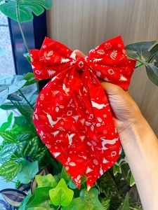 Détail d'un nœud de Noël rouge avec des motifs de rennes blancs et de flocons de neige