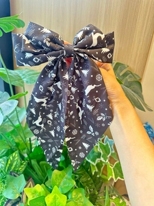 Détail d'un nœud papillon de Noël avec motif renne et flocon tenu à la main