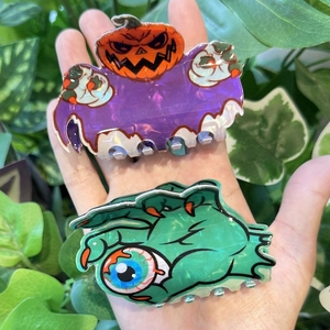 Gros plan sur des pinces à cheveux Halloween avec fantôme violet, citrouille et œil de monstre