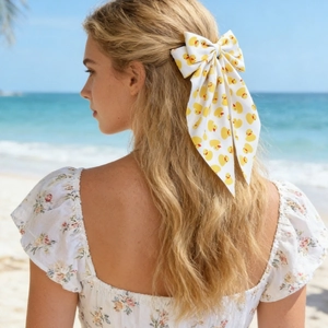 Détail d'un nœud papillon à motif canard jaune avec ruban sur une plage d'été