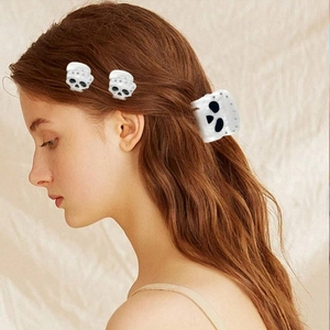 Close-up of sparkling rhinestone skull hair claw clips worn on long hair for Halloween