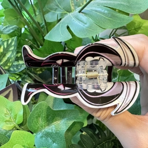 Close-up of Kuromi cartoon acrylic hair claw clip with skull details and metal spring