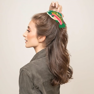 Realistic trout shaped hair claw clip made of multi-colored acetate on wavy brown hair