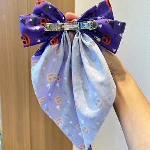 Halloween bow hair clip with purple fabric featuring pumpkin and ghost prints
