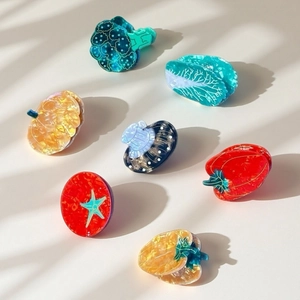 Flat lay detail of creative vegetable-shaped hair claws with glossy marble textures