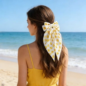 Nœud à cheveux blanc avec motifs canards jaunes et longs rubans sur fond de plage
