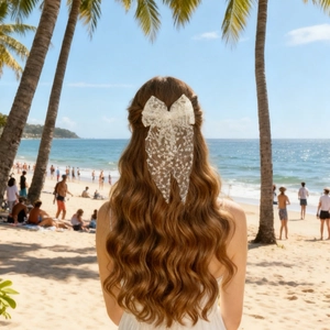 Detail of elegant white lace bow hair clip worn by a model on a sunny tropical beach