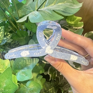 Blue denim texture heart pattern hair claw clip with Lucky lettering shown in hand